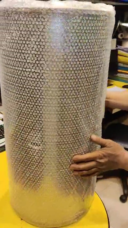 Cylindrical honeycomb-like object on a yellow surface with a blurred background