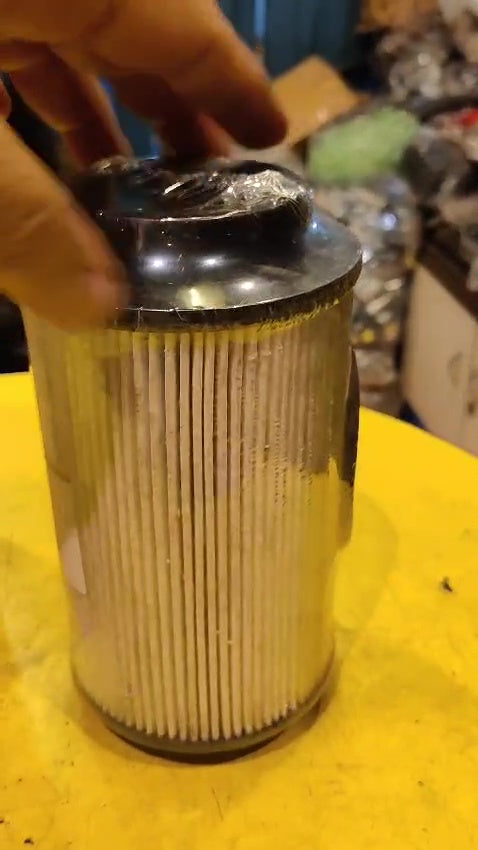Metallic cylindrical filter on a yellow surface
