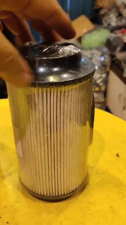Metallic cylindrical filter on a yellow surface