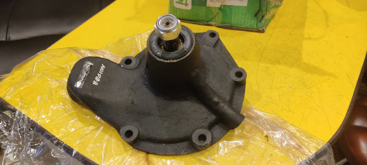 Black mechanical component on a yellow surface with a green box in the background